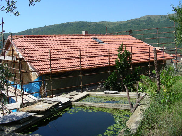 Tetto della casa di paglia coperto con tegole